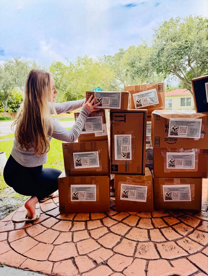 Volunteer stacking labeled shipping boxes of books bound for Eleuthera