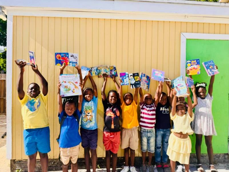 Summer-school students at EEO in Eleuthera holding up their new books